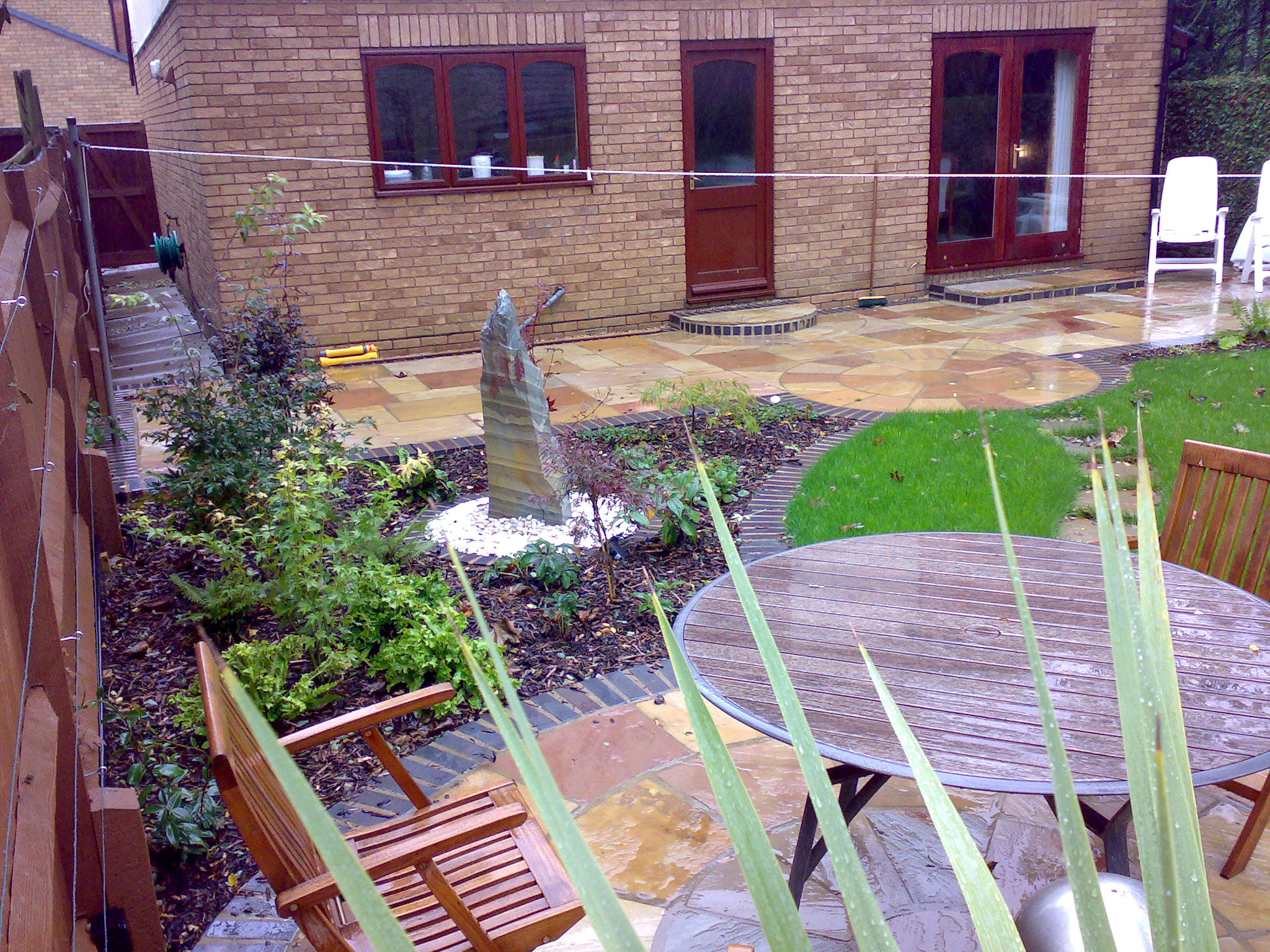 View towards house looking at the circular seating area with water feature in the midground